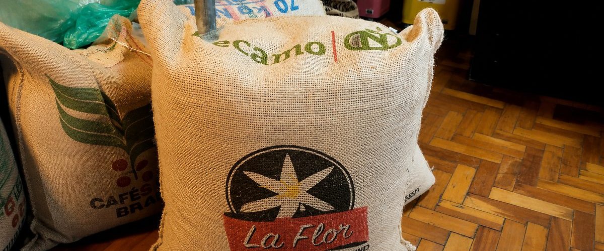 Green coffee sacks on the roastery floor — La Flor Strictly High Ground from Honduras